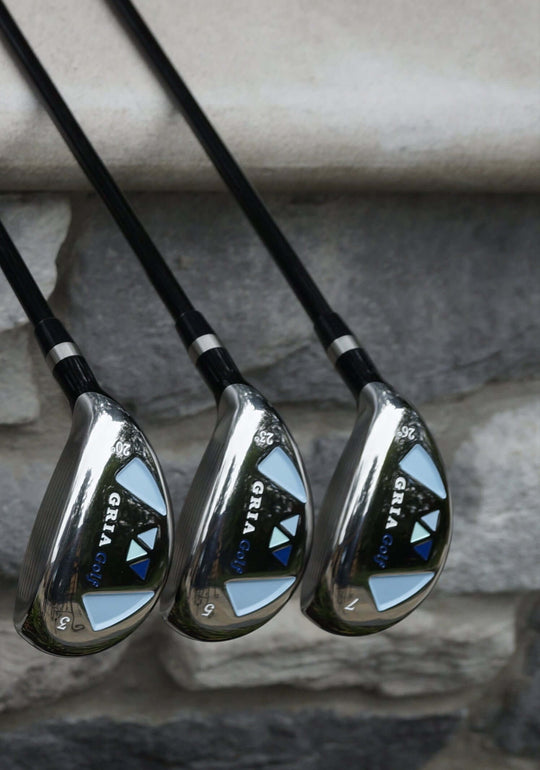 Set of golf clubs leaning against a stone wall.